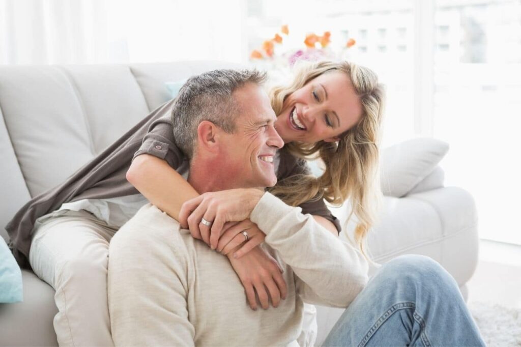 Couple enjoying a joyful moment together on a sofa, symbolizing emotional connection and well-being, relevant to CHS MedSpa's focus on enhancing health and confidence through personalized treatments like BHRT.