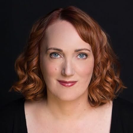 Woman with curly red hair and blue eyes, smiling softly against a dark background, representing the positive outcomes of personalized wellness solutions at CHS Med Spa.